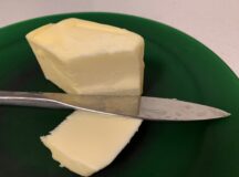 A pat of Canadian butter with a knife.