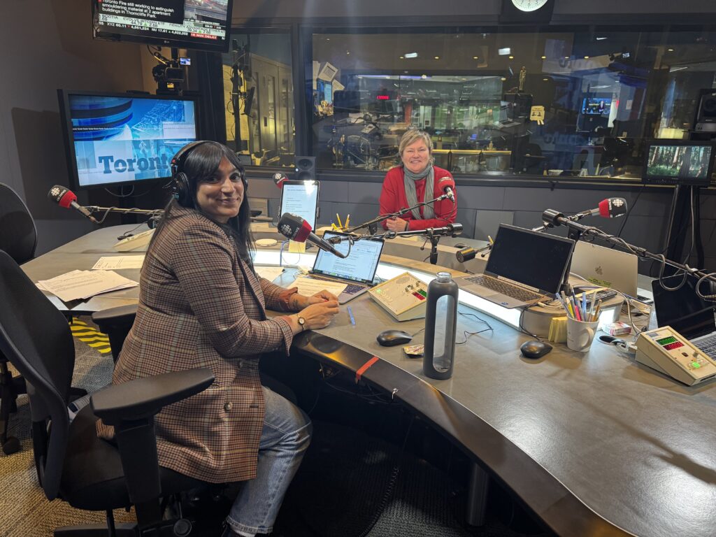 TKN's Joyce Grant (right, red sweater) and CBC Radio's Farrah Merali (left) discuss TKN and critical thinking on Here and Now.